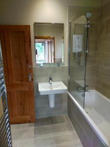 uma casa de banho com um lavatório, um chuveiro e uma banheira em Braeside Cottage - Adorable 2 Bedroom Eco-Friendly Character Cottage em Pitlochry
