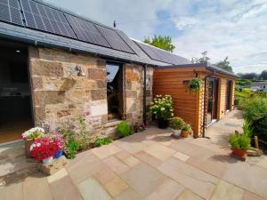 een huis met zonnepanelen op het dak bij Braeside Cottage - Adorable 2 Bedroom Eco-Friendly Character Cottage in Pitlochry