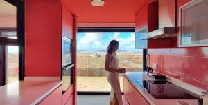 a woman standing in a kitchen looking out the window at Luxury Villa Sand Volcano in Villaverde