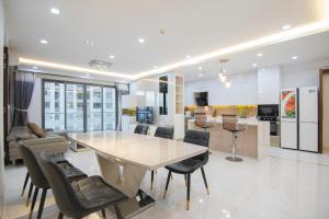 Una cocina y una sala de estar con mesa y sillas. en Luxury Gold Apartment 86 -Rooftop Pool Central City, en Ho Chi Minh