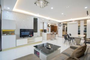 Una sala de estar con un sofá y un televisor. en Luxury Gold Apartment 86 -Rooftop Pool Central City, en Ho Chi Minh