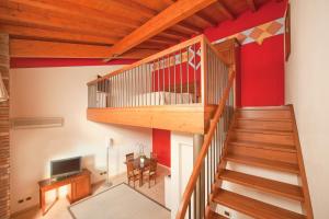 una scala in legno in un soggiorno con pareti rosse di Relais Corte Pontigliardo a Colà