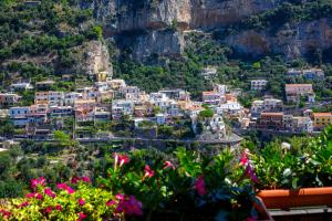 a view of a town on a hill with flowers at The Positaner in Positano