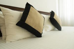 3 Kissen auf dem Bett in der Unterkunft Muthu villa in Ambalangoda