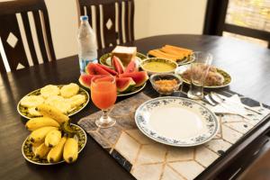 einen Tisch mit Teller mit Lebensmitteln und Obst darauf in der Unterkunft Muthu villa in Ambalangoda