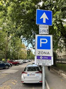 a parking sign on the side of a street with a car at Adorable, cosy apartment at the Heroes' Square Budapest in Budapest