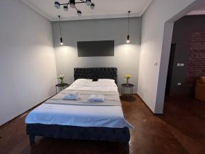 a bedroom with a bed with two towels on it at Gramophone Apartments in Bitola