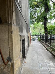 an empty sidewalk next to a building with a tree at Adorable, cosy apartment at the Heroes' Square Budapest in Budapest