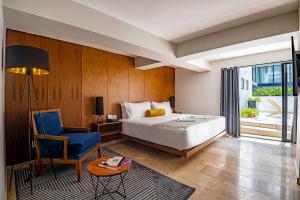 um quarto com uma cama, uma cadeira e uma mesa em HOTEL LUCA em Cidade do México