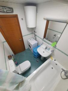a bathroom with a tub and a toilet and a sink at Oksana apartment in Podgorica +11 photos