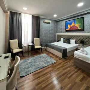 sypialnia z łóżkiem, stołem i krzesłami w obiekcie Hotel Empire Business Baku w mieście Baku