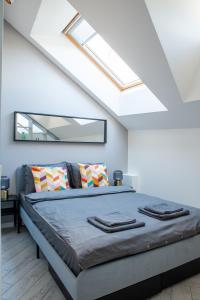 a bedroom with a large bed with a skylight at E.M. Studio In City Center in Kaunas