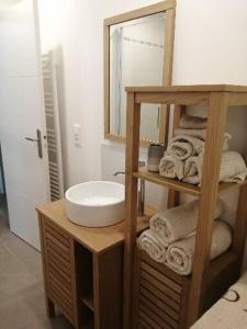 La salle de bains est pourvue d'un lavabo, d'un miroir et de serviettes. dans l'établissement Appartement Détente au Cœur du Cotentin, à Valognes