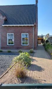 una casa de ladrillo con una pasarela de ladrillo delante de ella en De Poldersteeg, 