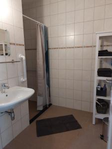 een witte badkamer met een wastafel en een douche bij De Poldersteeg 