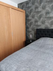 1 dormitorio con 1 cama grande y armario de madera en De Poldersteeg, 