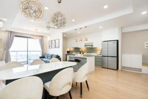 Una cocina y una sala de estar con mesa y sillas. en Luxury Gold Apartment 86 -Rooftop Pool Central City, en Ho Chi Minh 264 fotos más