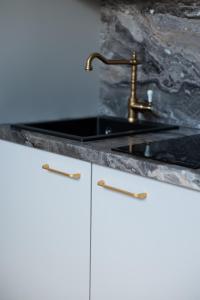 a kitchen sink with a black marble counter top at E.M. Studio In City Center in Kaunas