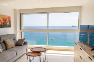 un soggiorno con divano e una grande finestra di Santa Margarita - Benisun a Benidorm