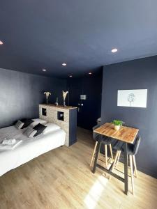 Spa & Love - Balnéo - Queen size - Cocooning في Aulnat: غرفة نوم بسرير وطاولة خشبية