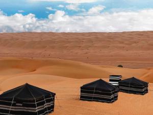 Arab desert camp في Al Raka: خيمتين سوداوين في الصحراء مع حقل رملي +31 صورة