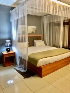 1 dormitorio con 1 cama con dosel en Top Lodge in Blantyre en Blantyre