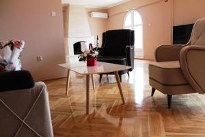 uma sala de estar com uma mesa de centro e cadeiras em Hotel Crnogorska Kuća em Podgorica