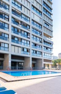 ベニドルムにあるSanta Margarita - Benisunのアパートメントの建物の正面にスイミングプールがあります。