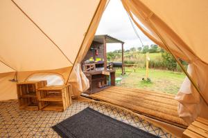 a tent with a wooden deck in a field at Roaches Retreat Eco Glampsite - Hen Cloud View Bell Tent in Upper Hulme