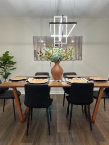 a dining room with a table with a vase and chairs at Casa Blanca - Minutes from Tech and GSU in Ruston