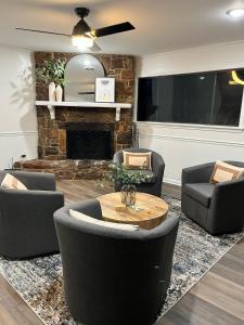 sala de estar con sillas, mesa y chimenea en Casa Blanca - Minutes from Tech and GSU en Ruston