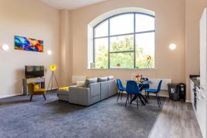 a living room with a couch and a table with chairs at The Arc - Stunning Luxury 2 Bed Duplex Apartment in Newcastle upon Tyne