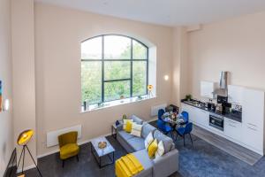 a living room with a couch and a window at The Arc - Stunning Luxury 2 Bed Duplex Apartment in Newcastle upon Tyne