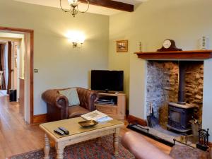 a living room with a couch and a fireplace at The Carters Cottage in Sedgwick