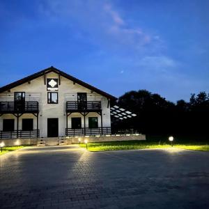 ein großes weißes Gebäude mit Lichtern davor in der Unterkunft Casa cu Flori Maramures in Baia Mare