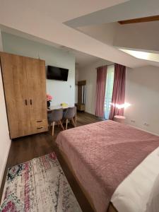 a hotel room with a bed and a table at Casa cu Flori Maramures 