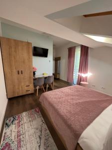 ein Hotelzimmer mit einem Bett und einem Tisch in der Unterkunft Casa cu Flori Maramures in Baia Mare + 40 Fotos