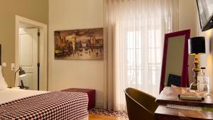 a bedroom with a bed and a desk and a window at Casa do Bairro by Shiadu in Lisbon