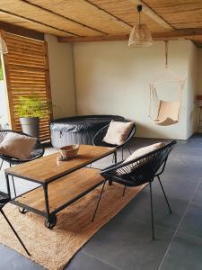 uma sala de estar com um sofá, uma mesa e cadeiras em ô Langevin , Logement avec véhicule em Saint-Joseph
