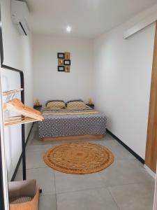 um quarto com uma cama e um tapete no chão em ô Langevin , Logement avec véhicule em Saint-Joseph