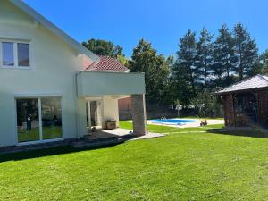 uma casa branca com um quintal com piscina em Villa EMIR em Saraievo