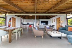 a living room with a blue couch and a table at Jolie Maison Vue Ocean et Moorea in Punaauia