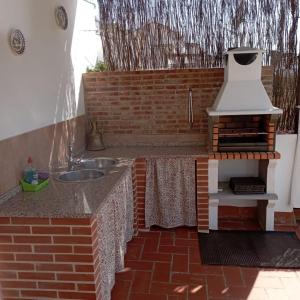 埃爾博斯克的住宿－Ático Los Arcos，一个带水槽和烧烤架的户外厨房