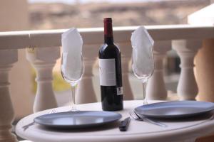 埃爾梅達諾的住宿－PARAISO DEL MEDANO ,CENTRICO，桌子上放着一瓶葡萄酒和两杯空酒