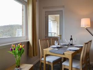 una sala da pranzo con tavolo, sedie e finestra di Finlaggan Apartment a Oban