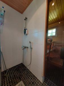 a shower with a hose in a bathroom at Wanha Rojola in Syöte