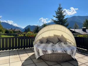 a bed on a patio with mountains in the background at Die Landhausvilla in Unterach am Attersee in Unterach am Attersee