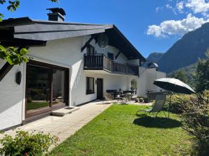 una casa con patio e ombrellone di Die Landhausvilla in Unterach am Attersee a Unterach am Attersee