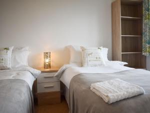 1 dormitorio con 2 camas con sábanas blancas y mesa en View Point, en Stokeinteignhead