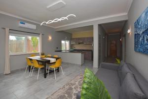 a living room and kitchen with a table and chairs at Bless Villa Apartment in Kiwengwa